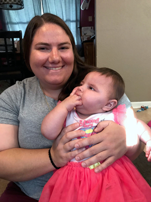 Makenzie in the lap of her EI Mentor Katie posing for a photo