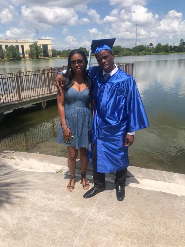 Sophia posing with her son who is wearing a graduation gown