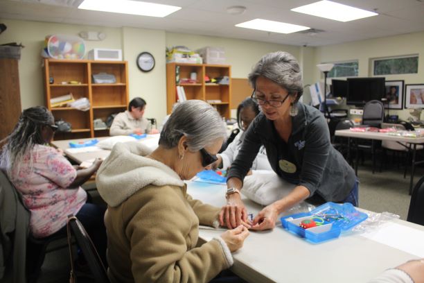 Tammy helping a Lighthouse client to learn how to sew