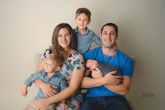 Matthew sitting on his mother's lap in a family photo with his mother, father and brother.