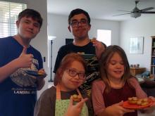 Lighthouse children's program student, Libby Lufkin, seen here sharing cookies with her two older brothers and her sister.