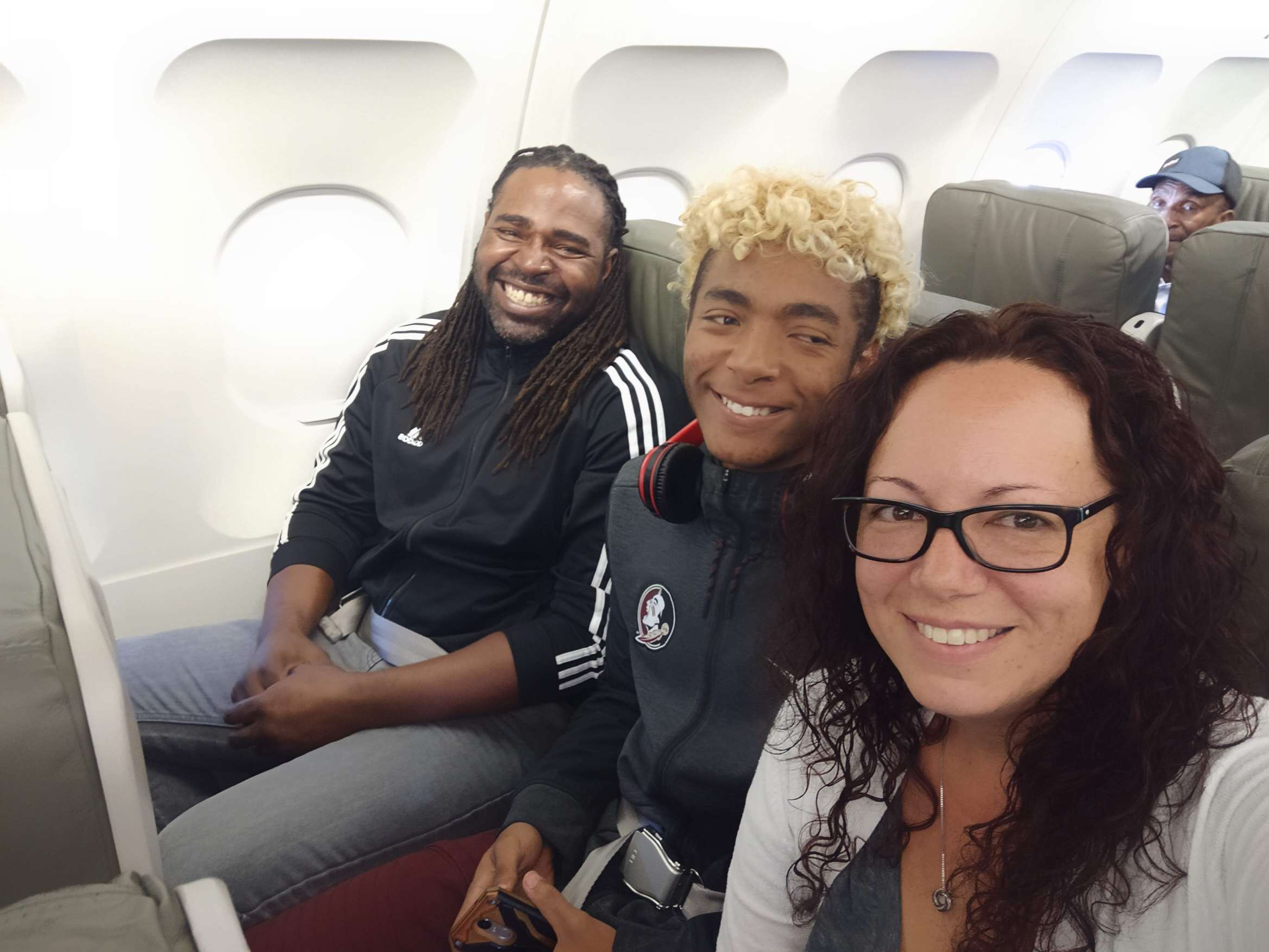 Tien sitting on an airplane with his family