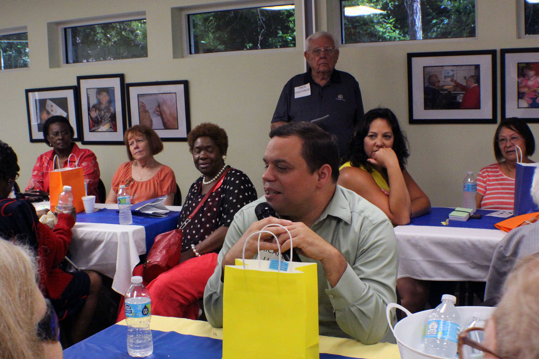 a picture of Lighthouse alumni sitting in groups at tables sharing stories at an Alumni reunion event