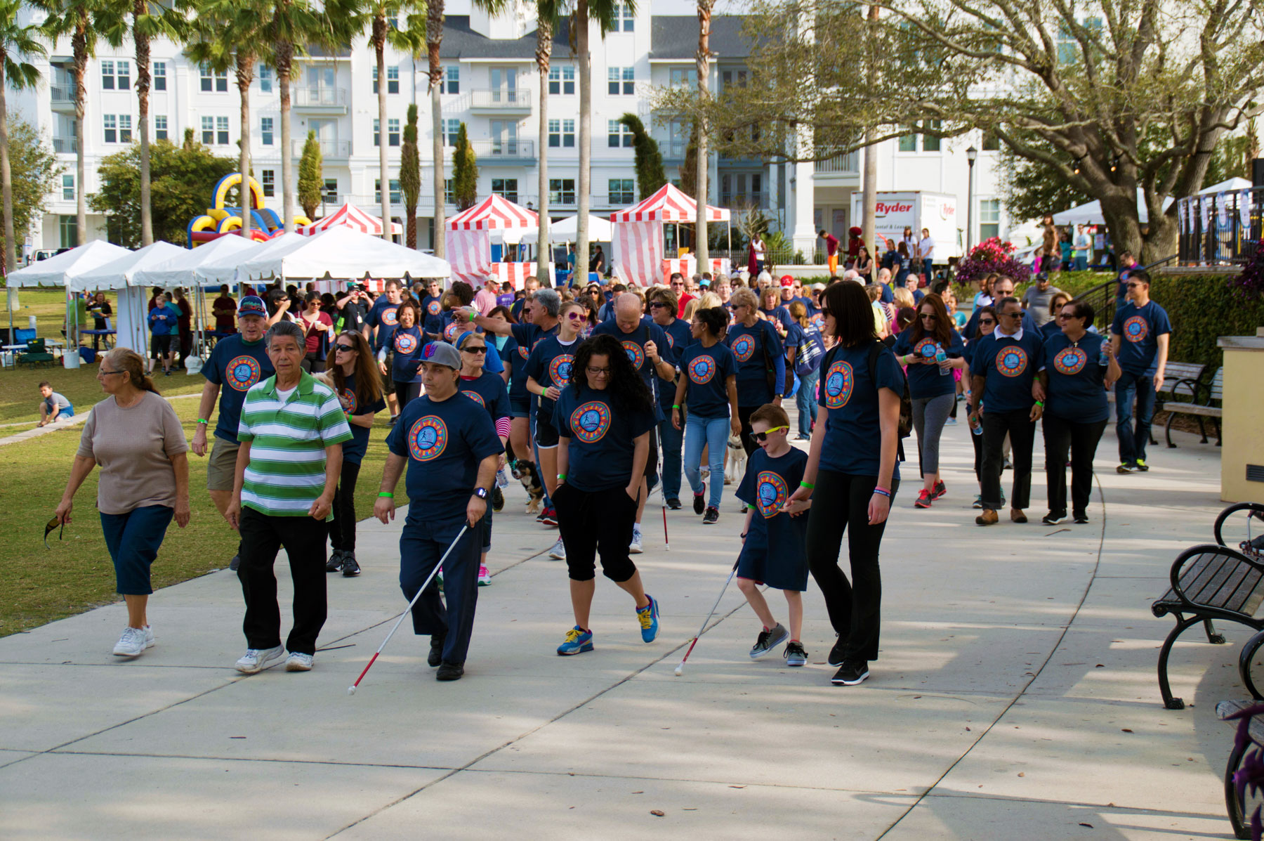 a group of walkers walking at Sight and Sole, some with white canes, some with blindfolds, and others giving and receiving sighted guide