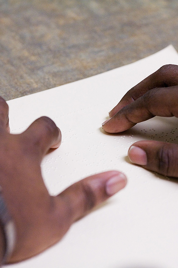 Image of person's hands reading braille